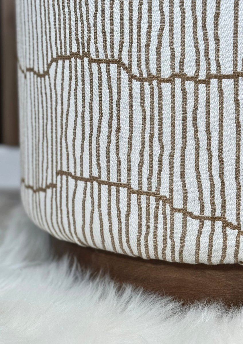 "Line-pattern designer pouf with brown fabric base"