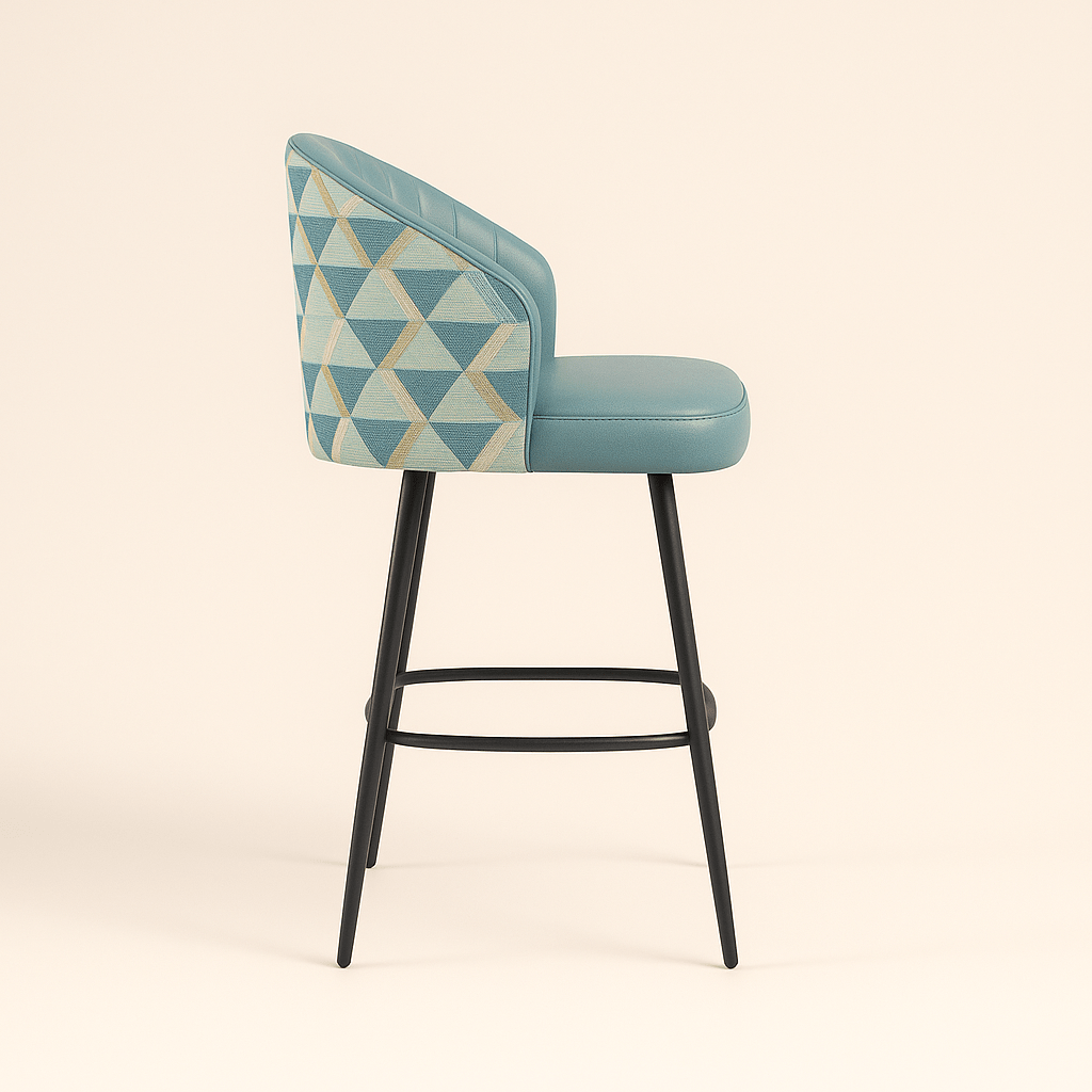 Modern bar and kitchen counter stool with teal upholstered seat and vertically channeled backrest, featuring patterned geometric fabric on the outer back and black metal tapered legs with a footrest, set against a neutral background.