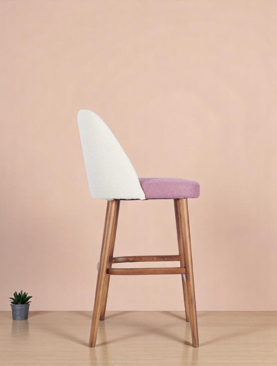 alt="Modern kitchen stool with padded seat and curved backrest supported by medium oak legs"