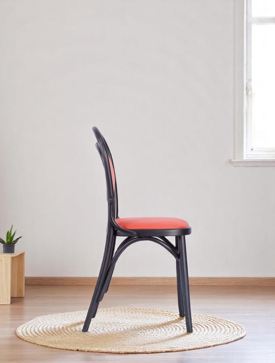 "Dining chair with upholstered orange oval backrest and black frame"