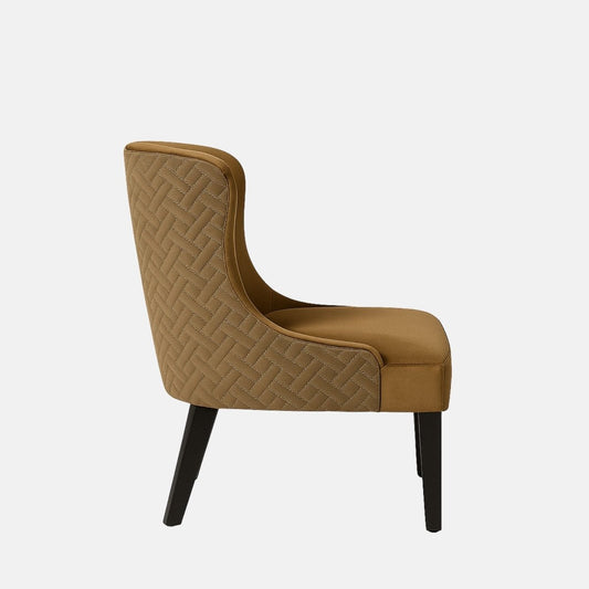 A modern accent chair with a high curved backrest, upholstered in brown velvet fabric with a subtle quilted pattern on the sides, supported by four dark wooden legs.