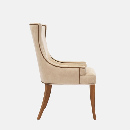 Upholstered wingback dining chair in soft beige fabric with gently curved arms, contrast piping, a cushioned seat, and dark wooden legs, shown on a white background