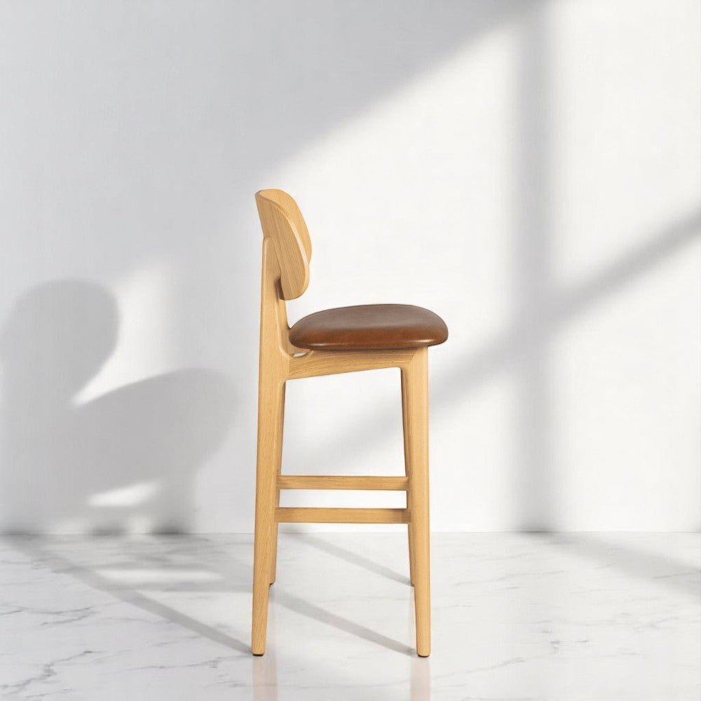 alt="Modern Italian-style bar stool with natural oak base and soft upholstered seat cushion"