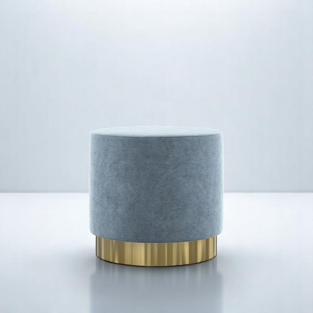 alt="Luxurious round pouffe in soft grey fabric with gold base, perfect for adding a touch of elegance"