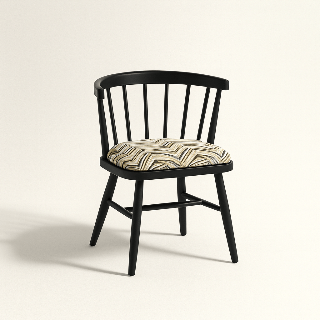 A modern black Windsor-style chair with a curved spindle backrest and four angled legs, featuring a cushioned seat upholstered in a geometric zigzag fabric with neutral tones. The chair is photographed against a light beige background with soft shadows for a clean, realistic presentation.