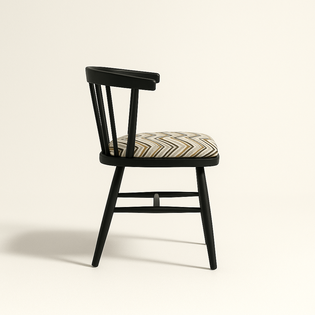 A modern black Windsor-style chair with a curved spindle backrest and four angled legs, featuring a cushioned seat upholstered in a geometric zigzag fabric with neutral tones. The chair is photographed against a light beige background with soft shadows for a clean, realistic presentation.