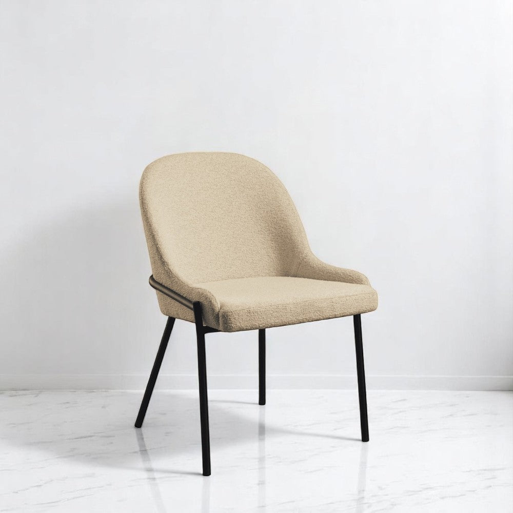 alt="Soft cream upholstered dining chair with comfortable padding and sleek black powder-coated legs"