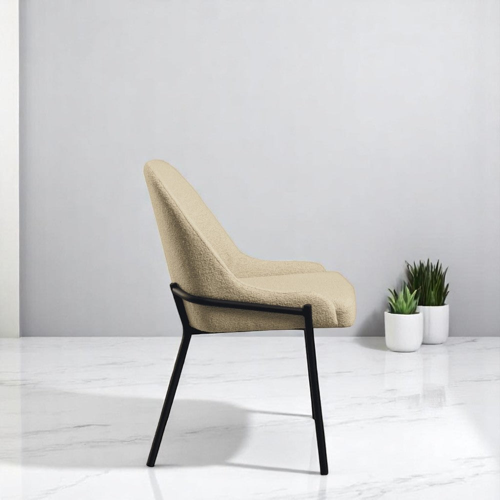 "Cream soft fabric dining chair with cushioned seat and backrest, featuring sleek black metal legs."