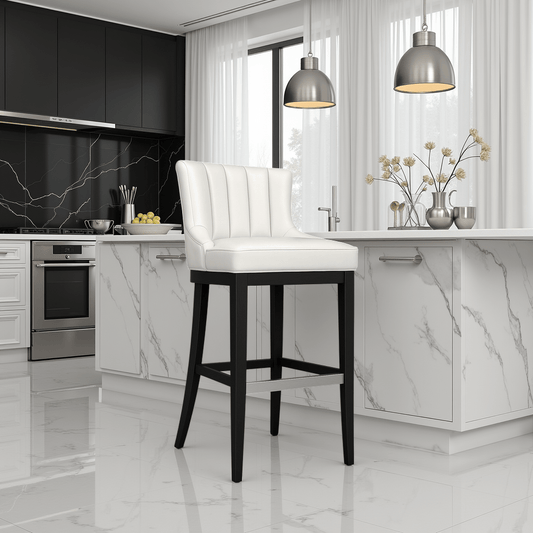 Modern white upholstered bar stool with black wooden legs in a luxury marble kitchen with pendant lighting and sleek cabinets.