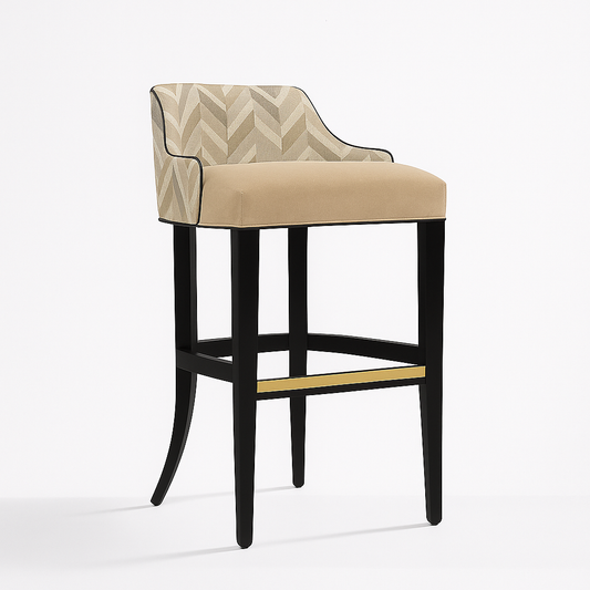 Elegant barstool with a chevron-patterned beige fabric backrest, plush beige velvet seat, black piping trim, matte black wooden frame, and a brass footrest, photographed in profile on a white background with a soft natural shadow.