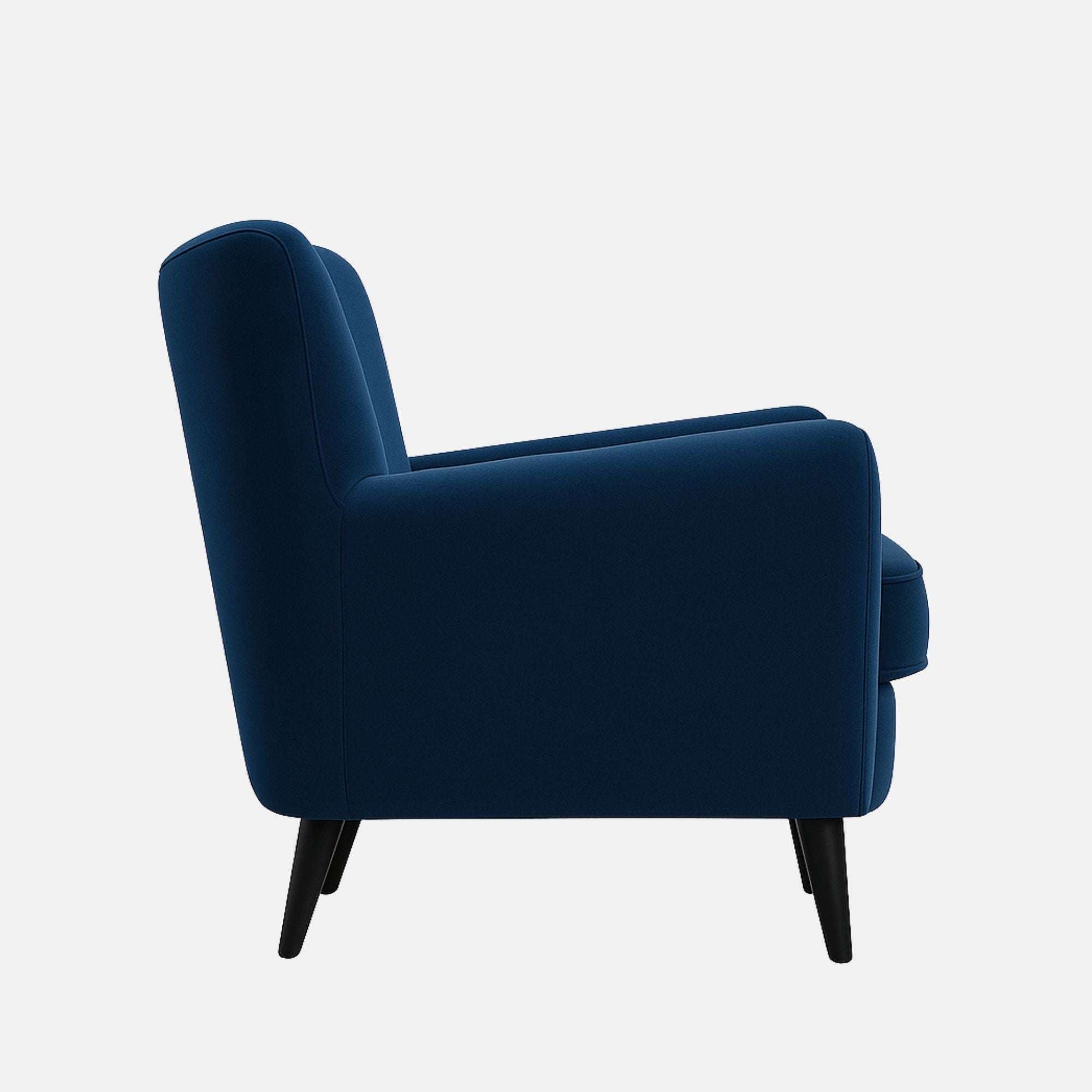 A modern armchair with tapered black wooden legs, wide armrests, and deep blue velvet upholstery.