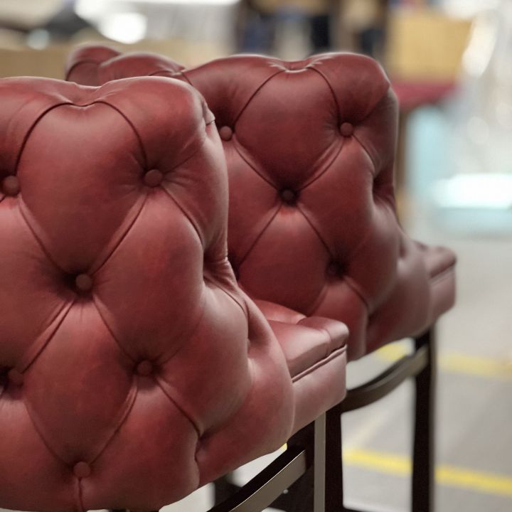 Luxury bar stool with deep button tufted red leather backrest in Chesterfield style, ideal for bars, restaurants, and premium interiors