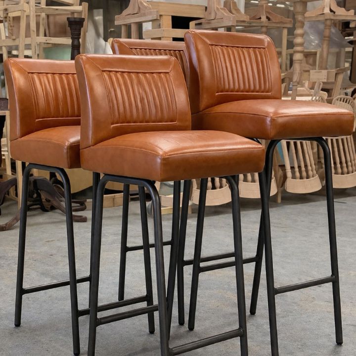 Industrial style bar stool with brown leather upholstery and ribbed backrest, featuring black metal legs, ideal for bars and modern hospitality interiors