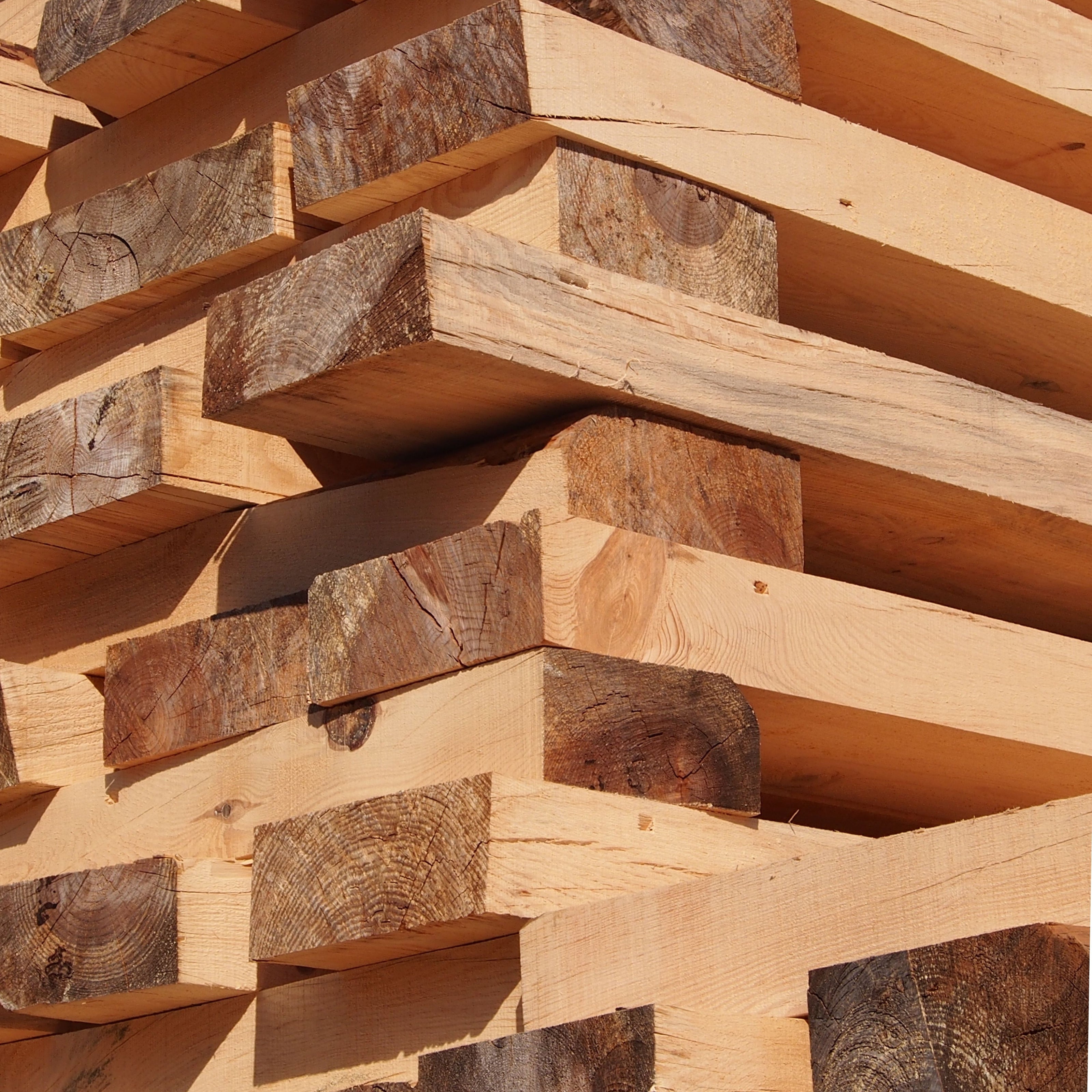 Stack of freshly cut, kiln-dried wooden beams ready for crafting sustainably sourced furniture frames such as bespoke chairs and bar stools.