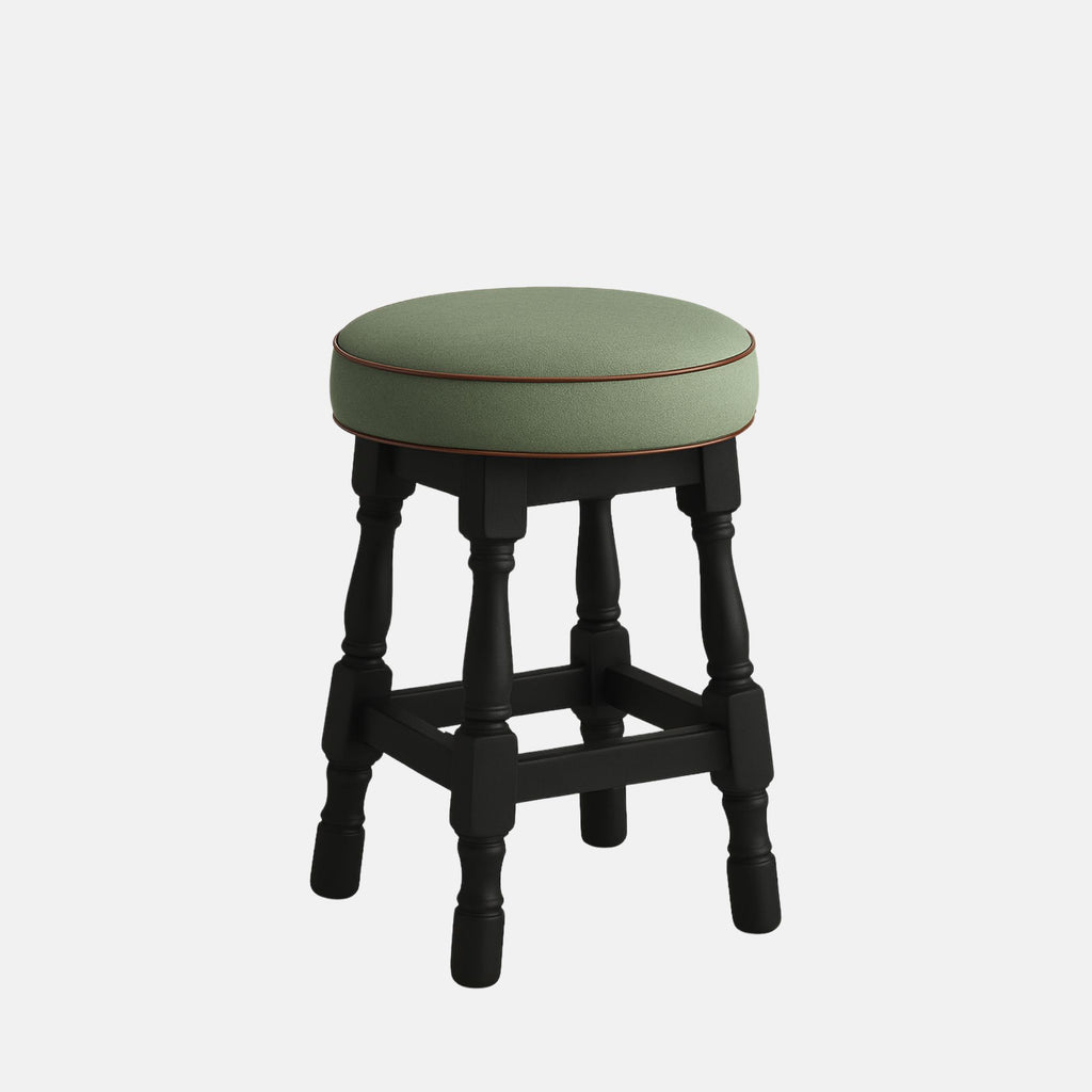 Tudor Low Stool by Lux Seat – compact round stool with a soft sage-green upholstered seat and dark black wooden legs featuring turned details, ideal for lounges, bars, and modern interiors
