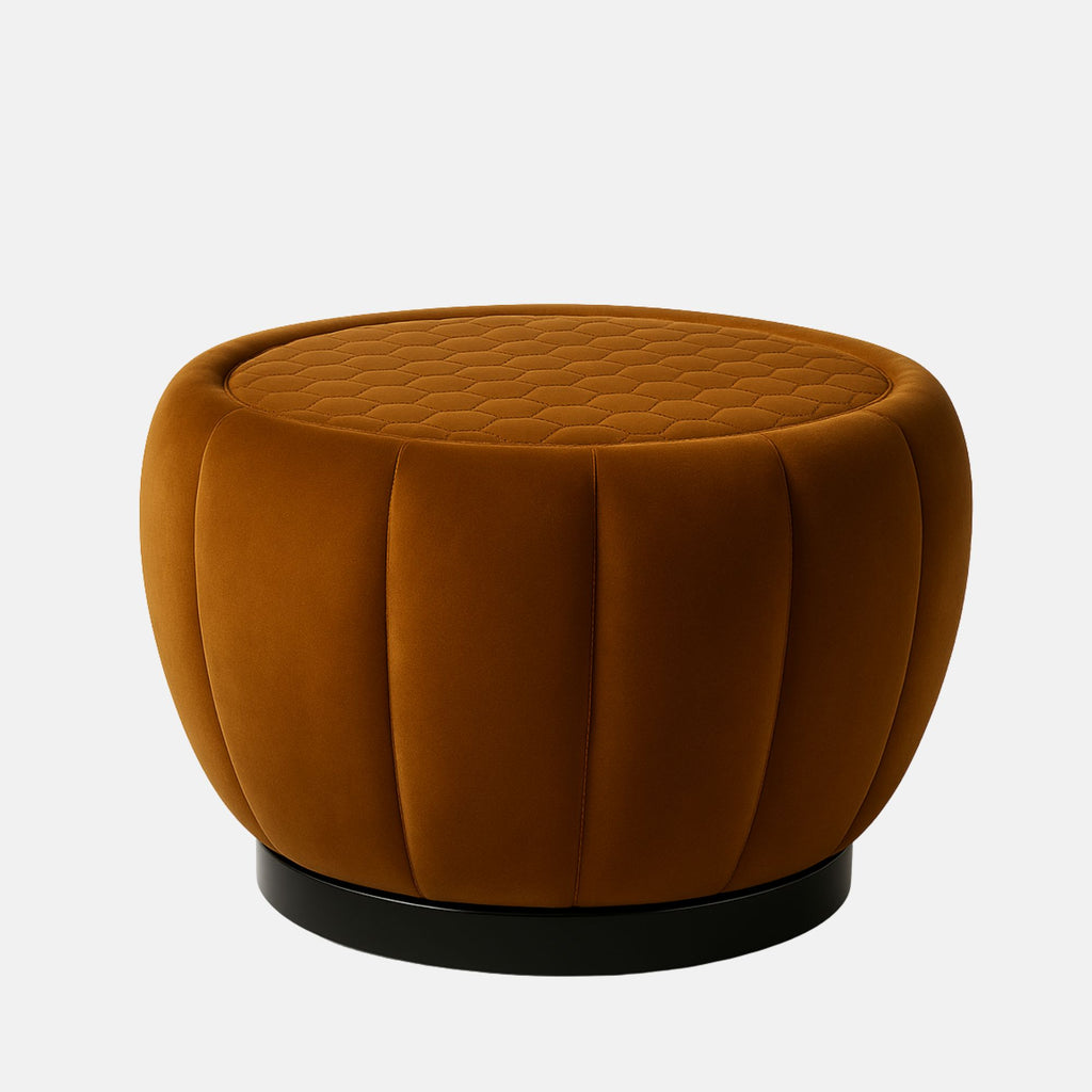 Rust velvet round ottoman with quilted top and vertical panel design on black base modern upholstered footstool or coffee table for living room or hotel lounge.