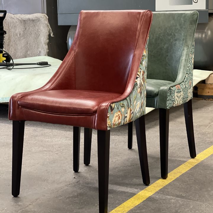 Modern dining chair with leather front seat and floral patterned backrest, featuring dark wooden legs, ideal for restaurants and hospitality interiors