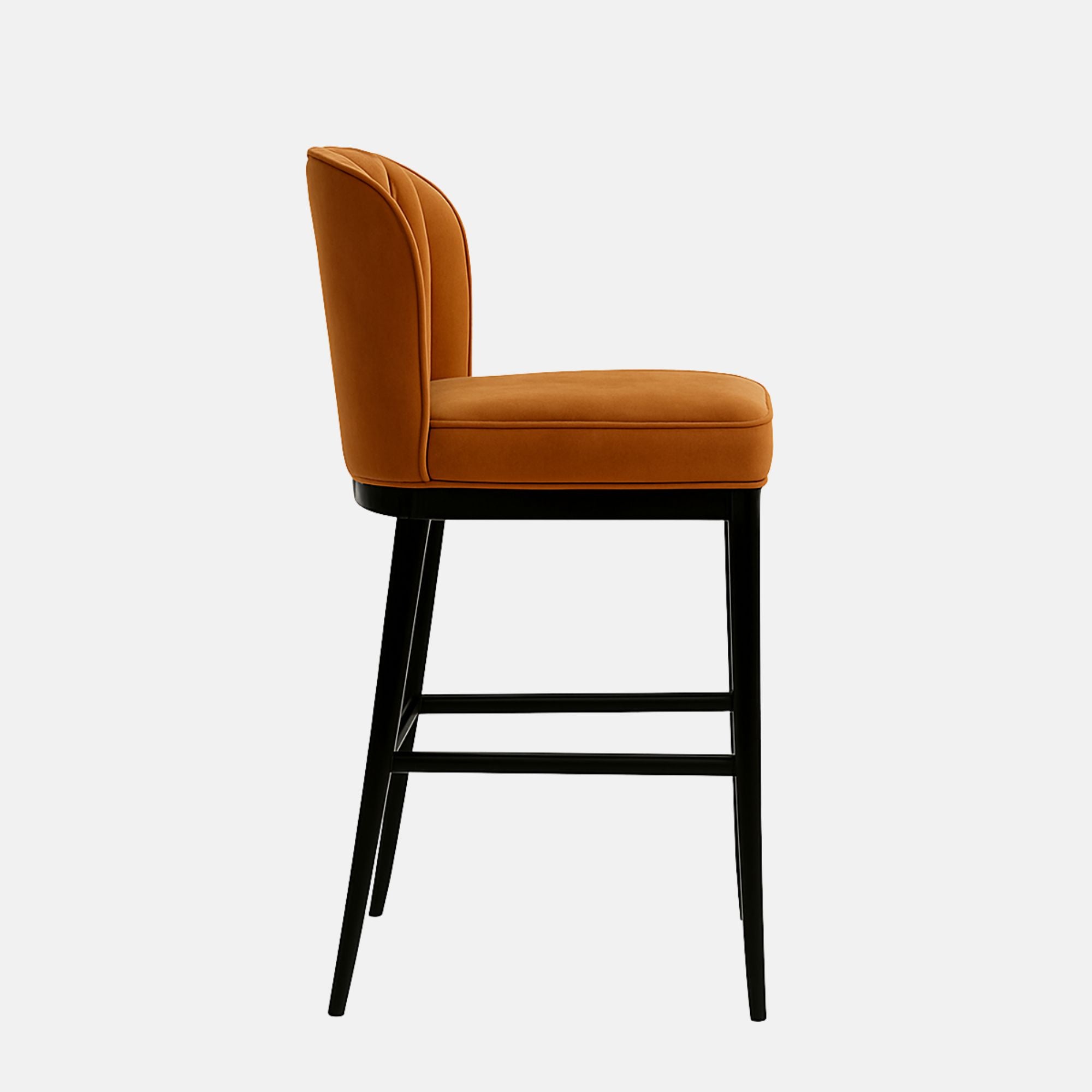 Bar stool with a camel-coloured, vertically channel-tufted backrest, matching cushioned seat, and black tapered legs with footrests