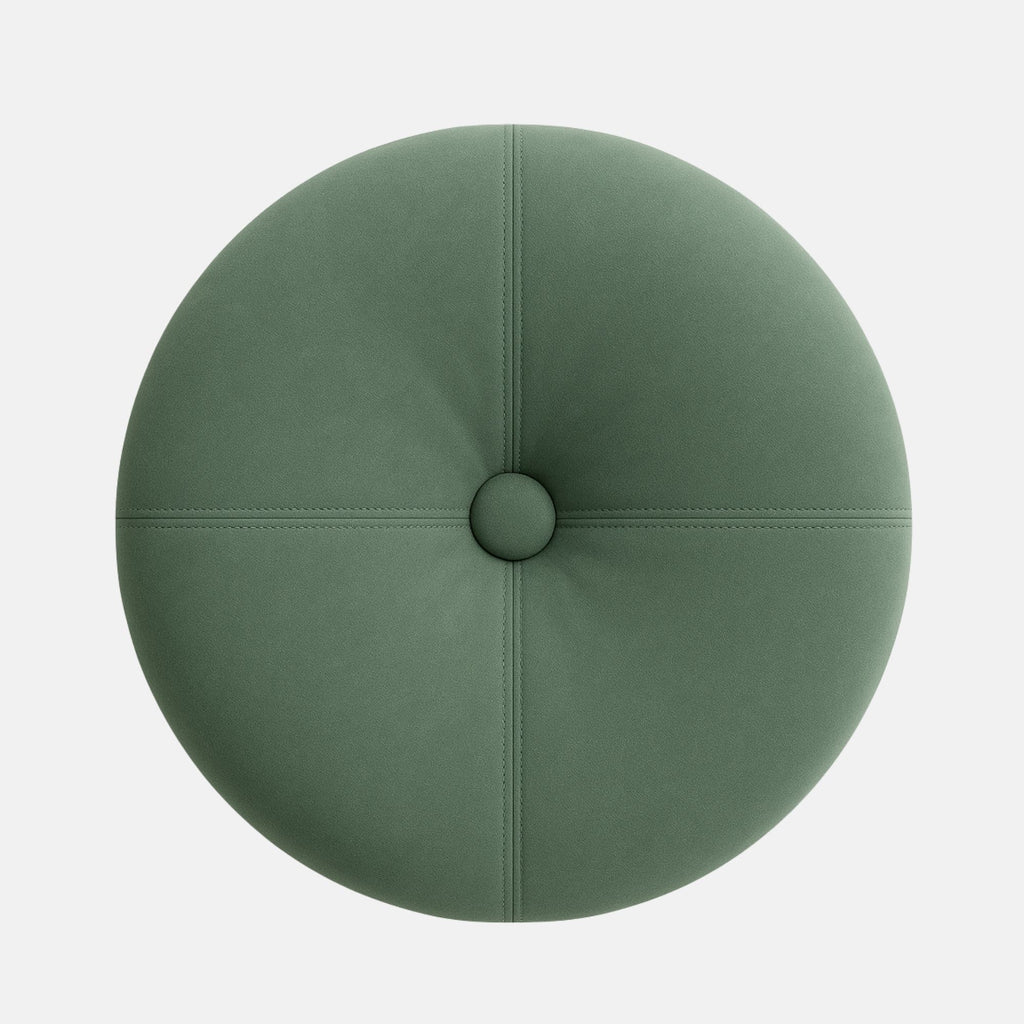Round upholstered ottoman with a tufted top in soft sage green fabric, accented by visible stitching and a dark wooden base. The design is modern and elegant with a smooth, cushioned finish