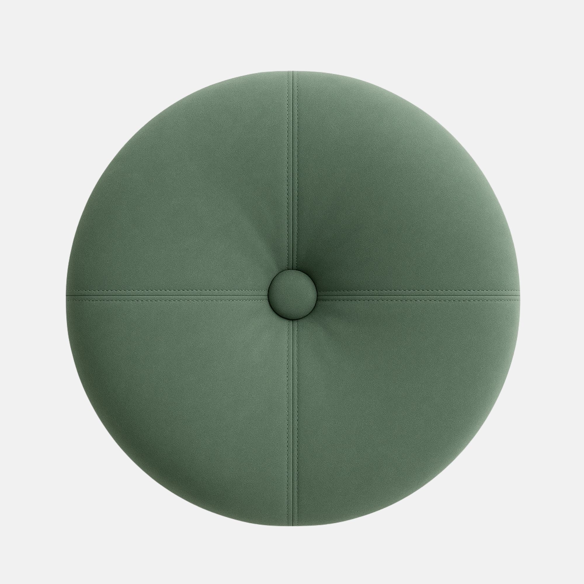 Round upholstered ottoman with a tufted top in soft sage green fabric, accented by visible stitching and a dark wooden base. The design is modern and elegant with a smooth, cushioned finish