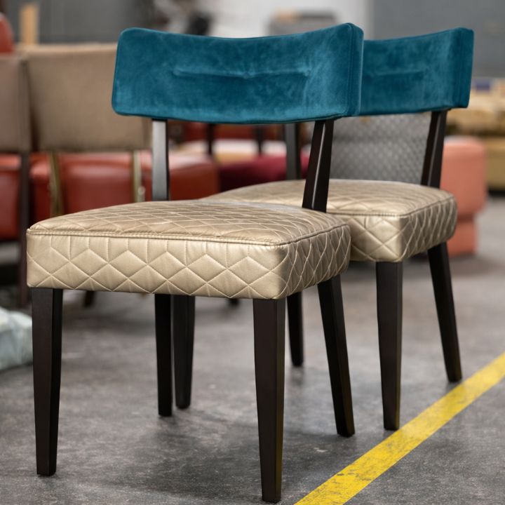 Contemporary dining chair with quilted leather seat and teal velvet backrest, featuring dark wooden legs, ideal for restaurants and hospitality interiors
