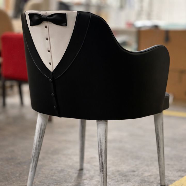 Unique dining chair with tuxedo-style upholstery featuring black and white design with bow detail, ideal for themed restaurants and stylish interiors