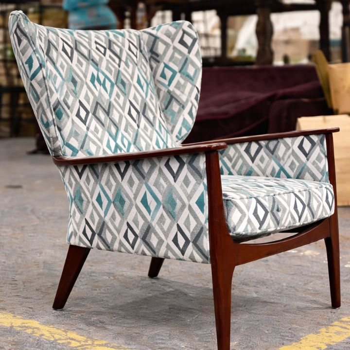 Stylish wingback lounge chair with geometric patterned upholstery and wooden frame, ideal for hotels, lounges, and modern interiors
