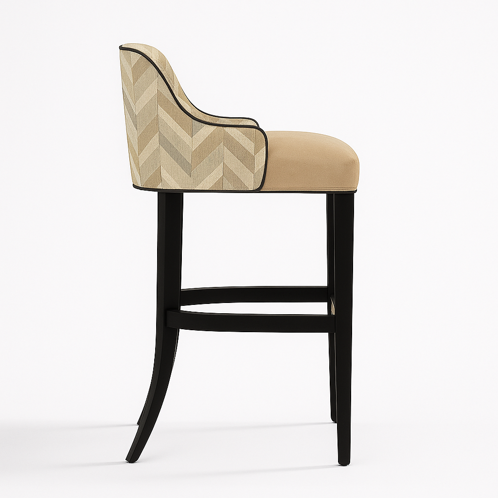 Elegant barstool with a chevron-patterned beige fabric backrest, plush beige velvet seat, black piping trim, matte black wooden frame, and a brass footrest, photographed in profile on a white background with a soft natural shadow.
