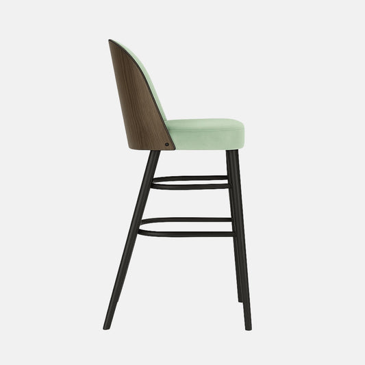 Modern bar stool with a light green upholstered seat and rounded backrest, supported by slim black wooden legs with curved double footrests.

