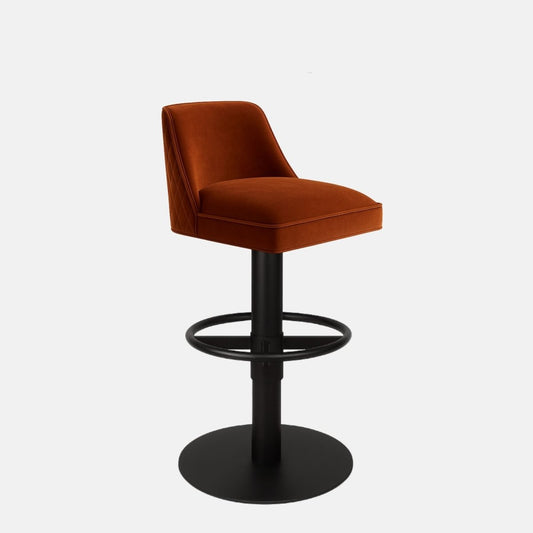 Rust-colored upholstered bar stool with a low curved backrest, black circular footrest, and round black metal base on a white background.