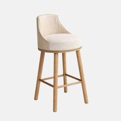 Elegant bar stool with cream upholstered seat and curved backrest, featuring studded trim and light wooden legs with footrest, ideal for bars and hospitality interiors
