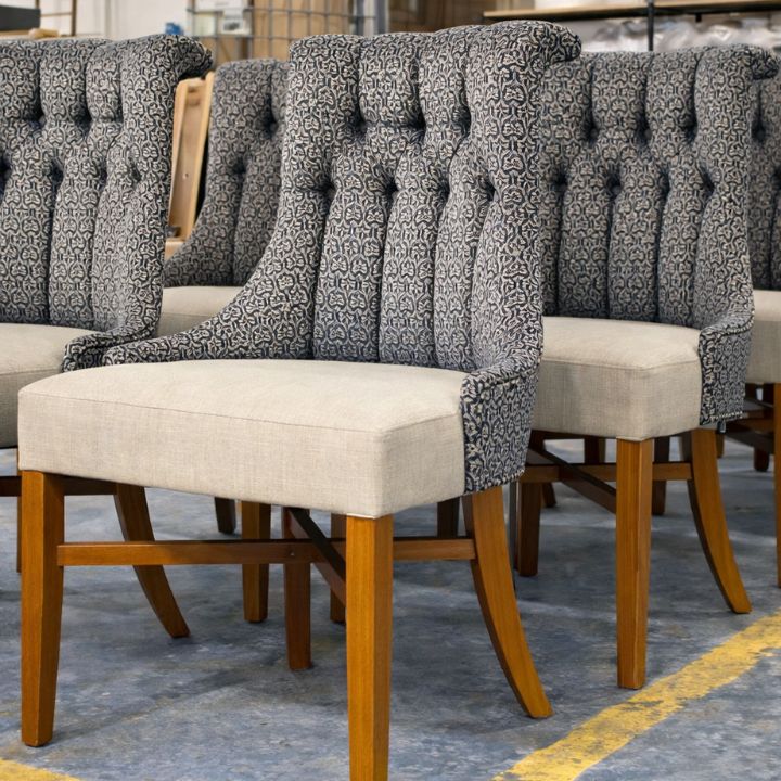 Dining armchair with patterned upholstered backrest and plain fabric seat, featuring wooden legs, ideal for restaurants and hospitality interiors

