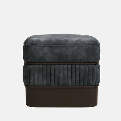 Dark grey upholstered ottoman with ribbed lower panel and smooth cushioned top on wooden base modern square footstool for living room or hotel lounge.