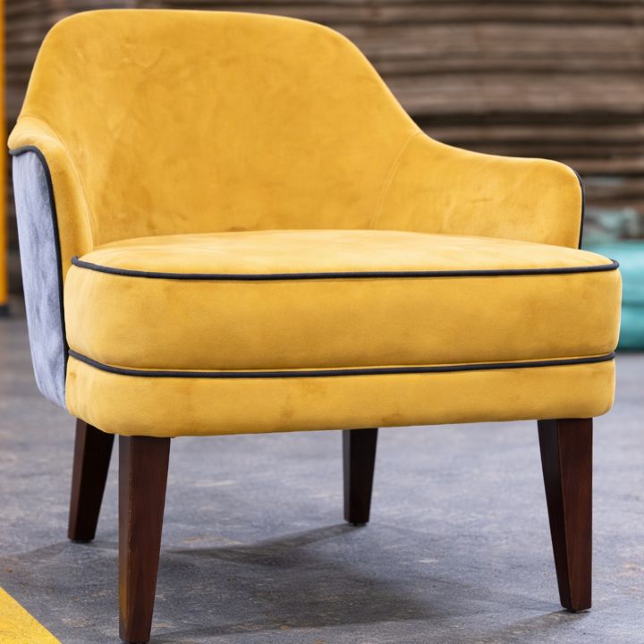 Modern lounge chair with mustard velvet upholstery, curved back and wooden legs, ideal for hotels, lounges, and stylish interiors