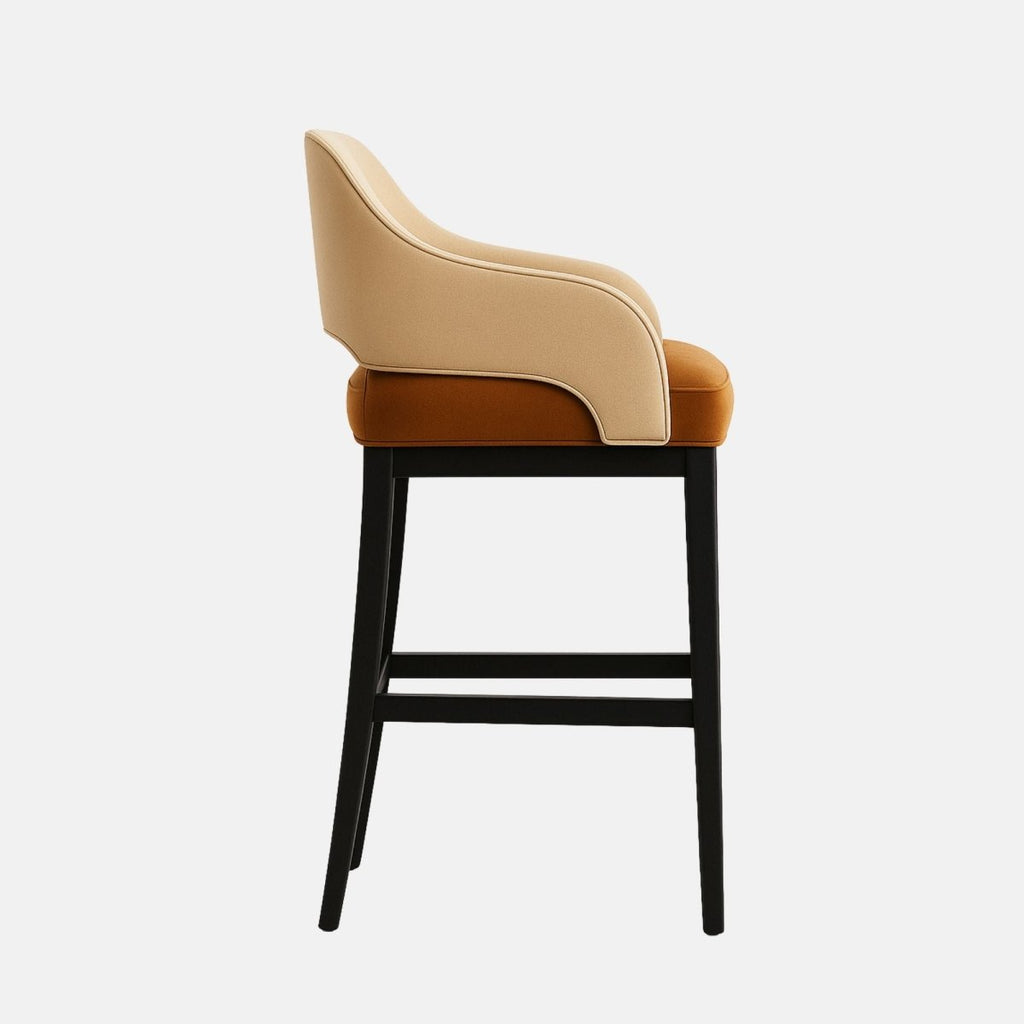 Modern bar stool with a curved backrest and arm design, upholstered in light beige leather with a cushioned rust-orange velvet seat. The chair features a black wooden frame with a brass footrest accent, combining comfort with contemporary elegance