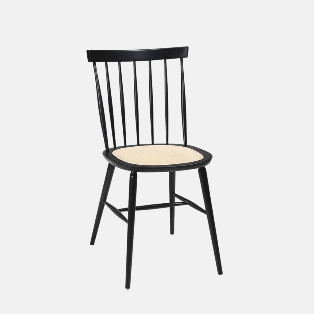 Black wooden dining chair with a spindle backrest and light woven rattan seat, featuring angled legs with cross supports.