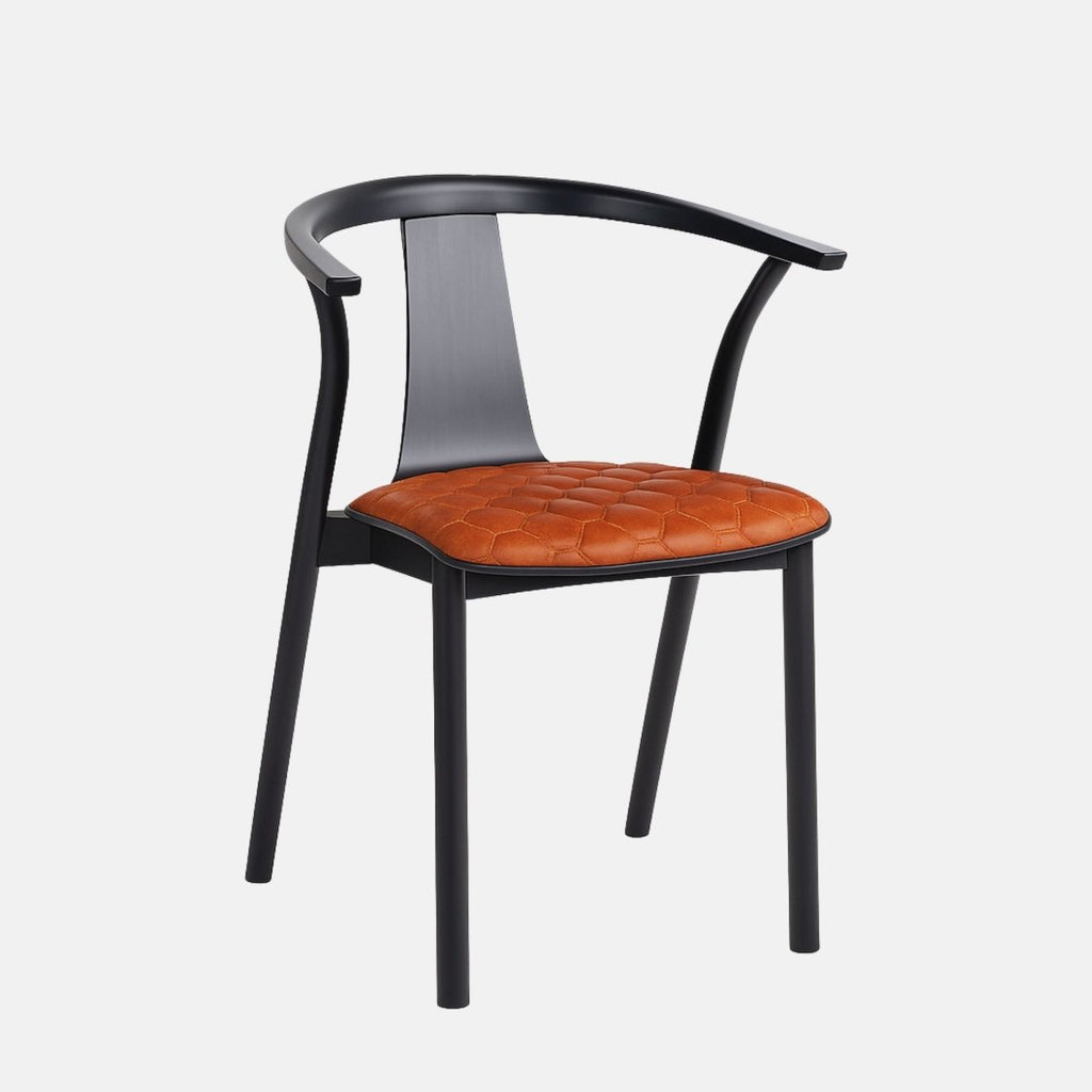 Modern dining chair with a curved black wooden frame and armrests, featuring a cognac brown leather seat with quilted stitching, set against a light grey background