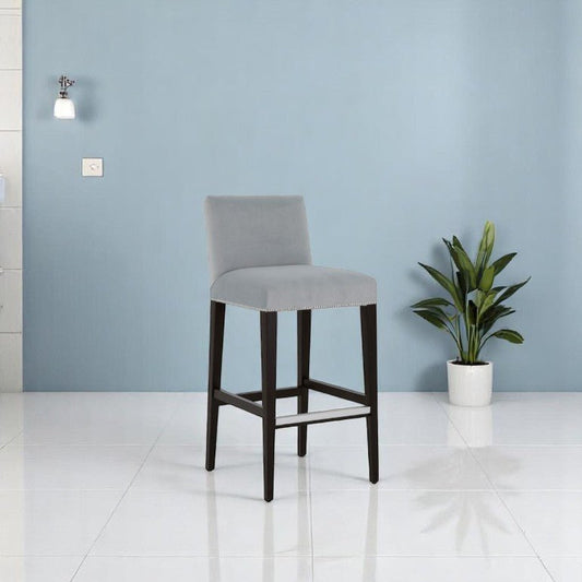 alt="Soft velvet bar stool with square seat, black wooden legs, and chrome metal leg rest"