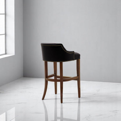 alt="Stylish black bar stool with leather upholstery and medium oak wood legs, perfect for contemporary spaces"