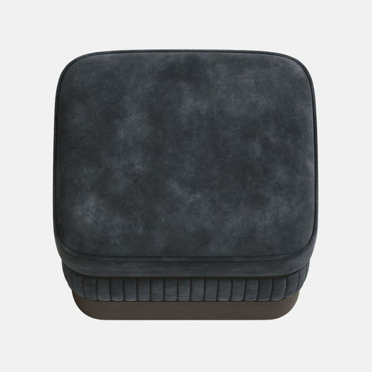 Dark grey upholstered ottoman with ribbed lower panel and smooth cushioned top on wooden base modern square footstool for living room or hotel lounge.