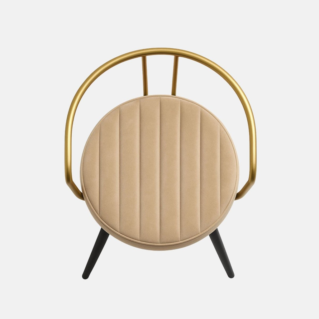 Modern dining chair with gold metal frame, cream upholstered round seat, and black tapered legs