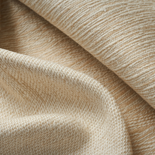 Close-up of beige upholstery fabric with soft woven texture and folds