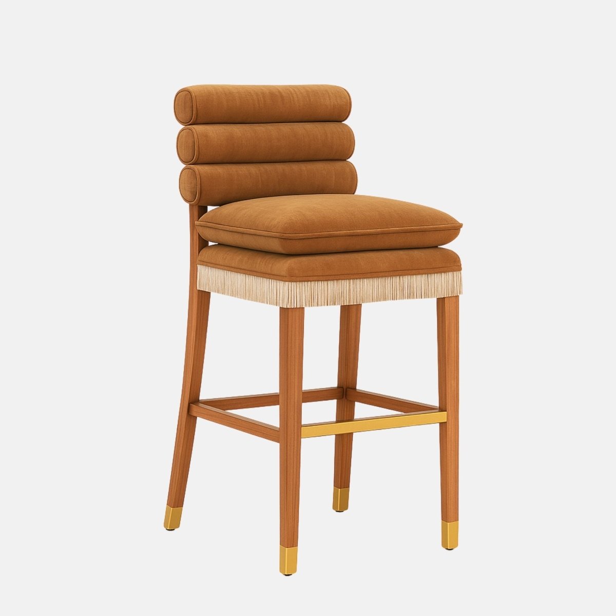 Front three-quarter view of a tan upholstered bar stool with three stacked cylindrical back cushions, a thick seat cushion, fringe trim around the seat base, a wooden frame with a brass footrest, and brass-capped legs on a white background.