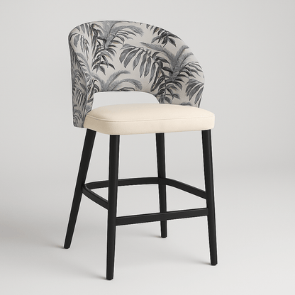 Side view of a contemporary barstool with tropical leaf-patterned upholstery, cream upholstered seat cushion, curved backrest, black wooden legs, and integrated footrest modern furniture design, neutral colour palette, stylish bar seating.