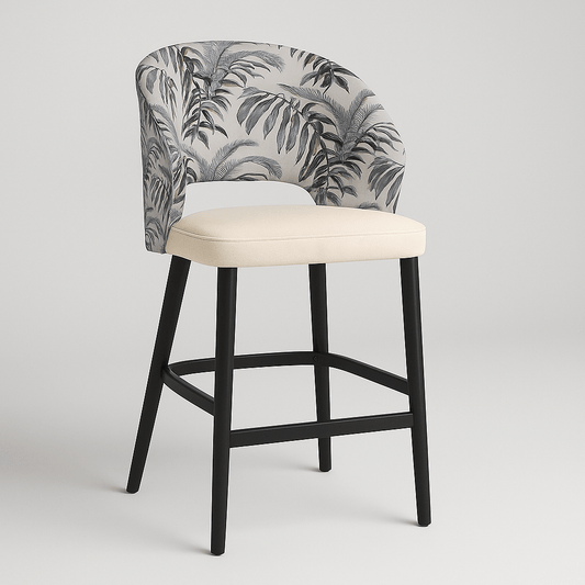 Side view of a contemporary barstool with tropical leaf-patterned upholstery, cream upholstered seat cushion, curved backrest, black wooden legs, and integrated footrest modern furniture design, neutral colour palette, stylish bar seating.
