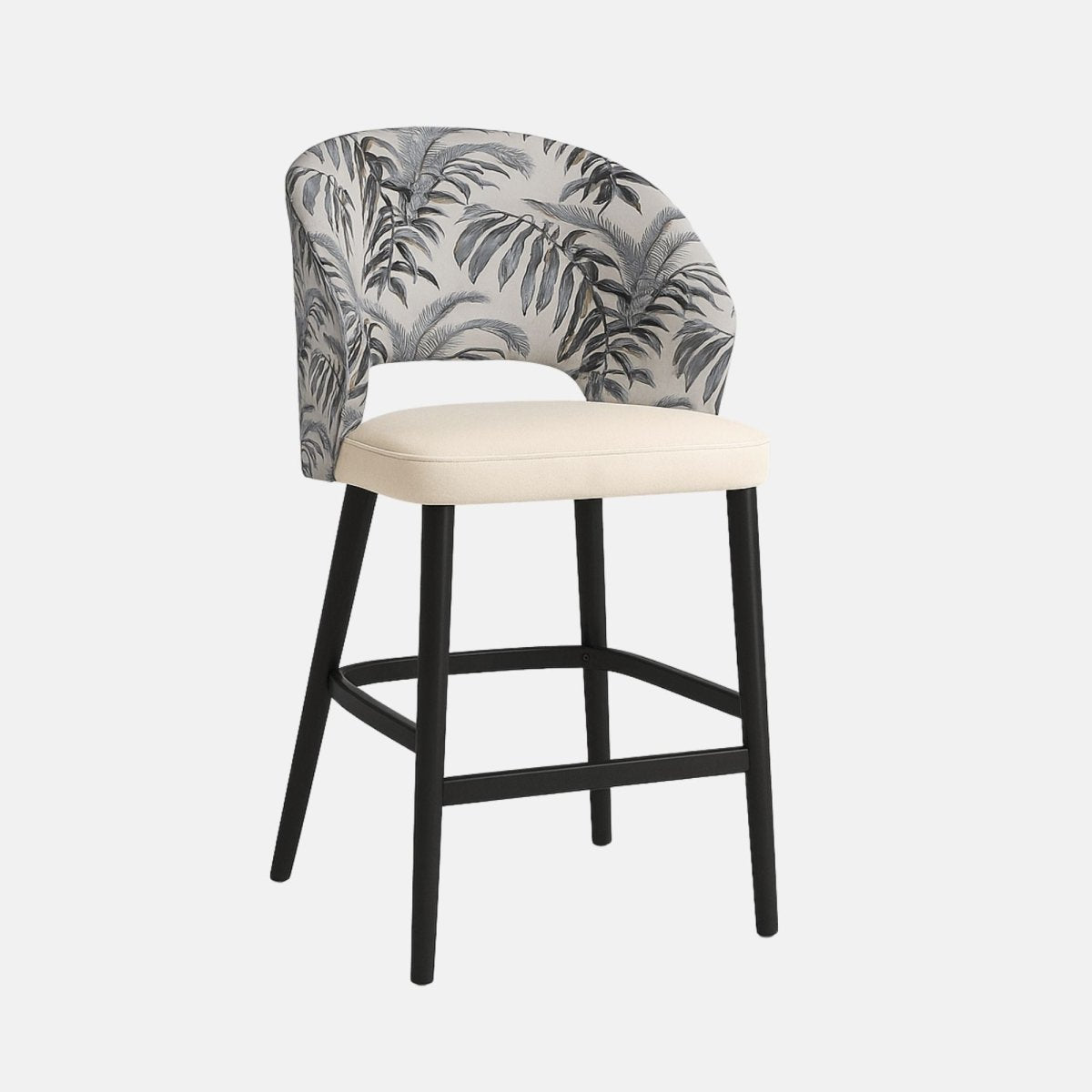 Modern bar stool with curved backrest upholstered in grey fabric with black tropical leaf pattern, cream cushioned seat, and black wooden legs with footrest.