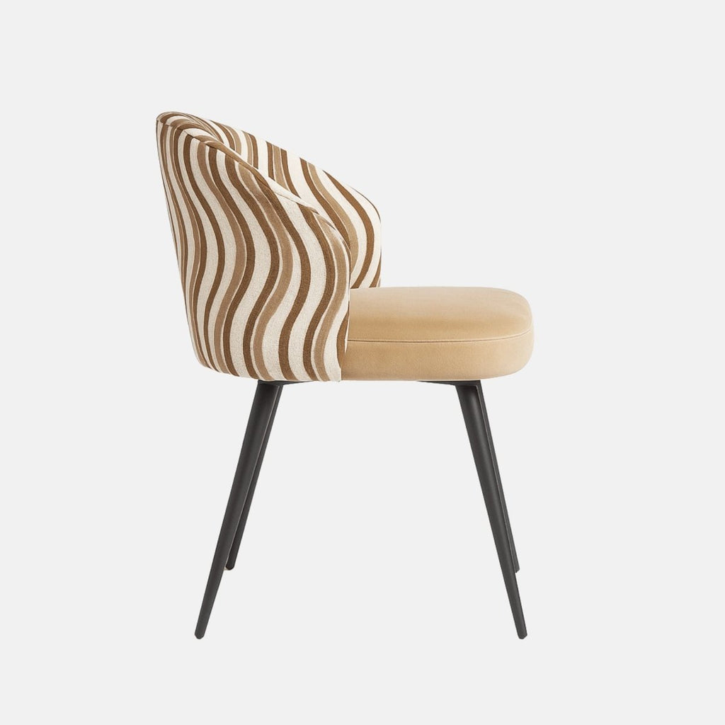 Modern dining chair with curved backrest upholstered in beige and brown wavy patterned fabric, cushioned tan seat, and slim black tapered legs.