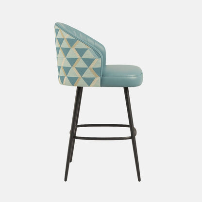 Modern bar stool with teal upholstered channel-tufted backrest, matching cushioned seat, geometric patterned side panels, and slim black legs with footrest