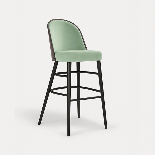 A barstool with pastel green velvet upholstery, black legs, and a dark wood veneer backrest, shown in a straight side profile view against a plain light background with a subtle shadow.