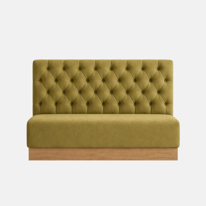Upholstered banquette bench in green fabric with button tufted backrest and wooden base, designed for booth-style seating on a neutral background.